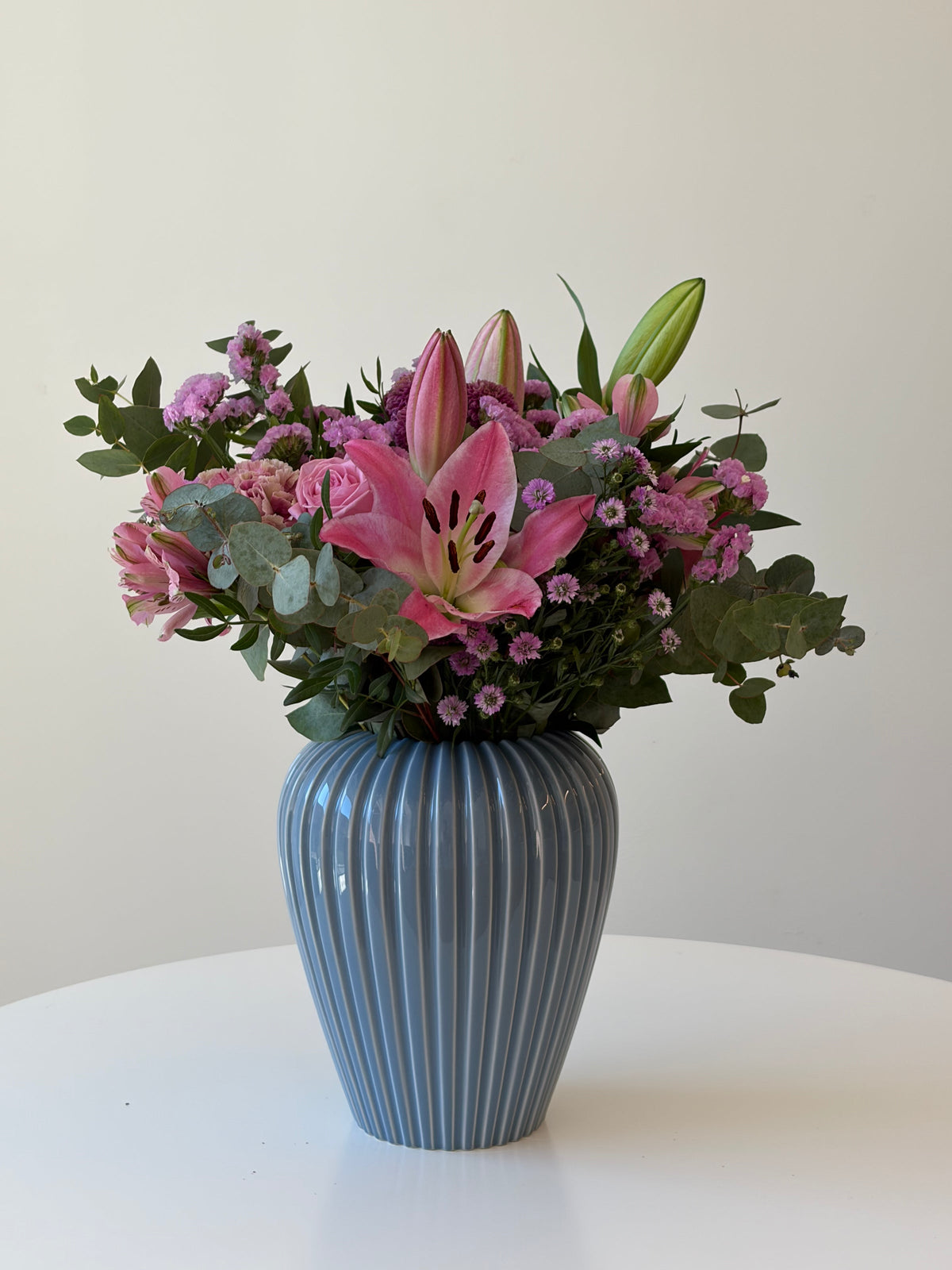 Overraskelsesbuket til hende med sæsonens blomster i bløde toner, leveret i Køge